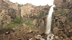 there is a very tall waterfall in the mountains