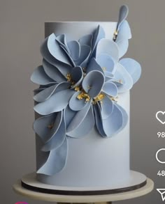 a white and blue wedding cake with flowers on the top is featured in this ad