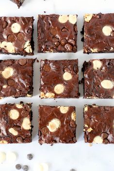 chocolate brownies with peanut butter and oreo chips arranged in rows on a white surface