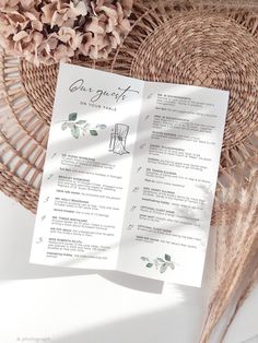 a menu sitting on top of a wicker basket next to a flower vase and paper