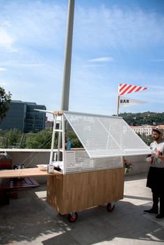 a man standing next to a white and wooden structure