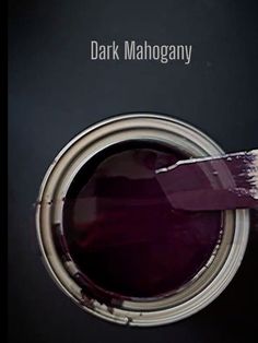 a paint can with a brush in it and the words dark mahogany above it