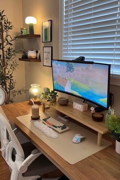 a desk with a computer monitor, keyboard and mouse on it next to a potted plant