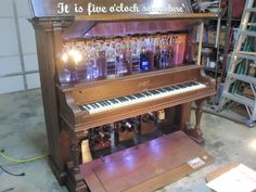 an old piano with some wine glasses on it's top and the words, it is free alcohol somewhere