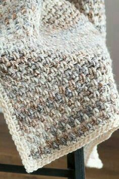 a crocheted blanket sitting on top of a chair