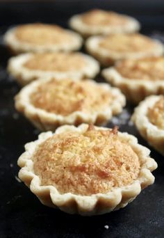 several small pies sitting on top of a black counter next to eachother