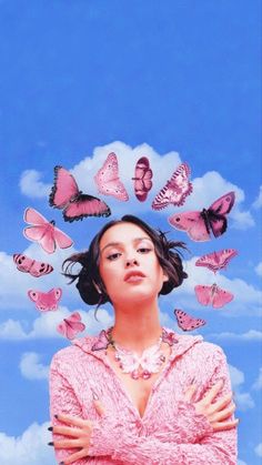 a woman with her arms crossed and butterflies flying over her head in the sky behind her