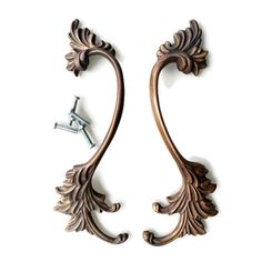 two decorative metal handles on a white wall