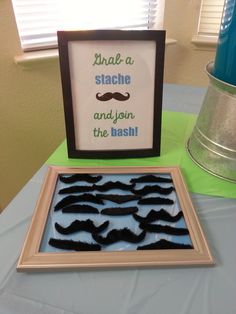 a table topped with framed pictures and fake moustaches