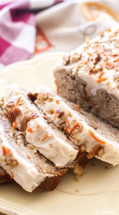 slices of carrot bread with cream cheese frosting and chopped nuts on top, sitting on a plate