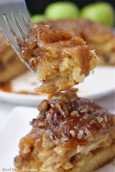 a fork is holding up a piece of apple pie