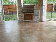 an outdoor kitchen with a grill and patio furniture