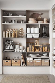 an organized pantry with white shelves and baskets