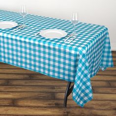 a blue and white checkered table cloth with two empty plates on it