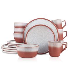 a set of red and white dinnerware on a white background with one plate, four cups and two saucers