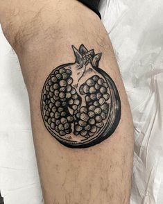 a black and white pomegranate tattoo on the leg