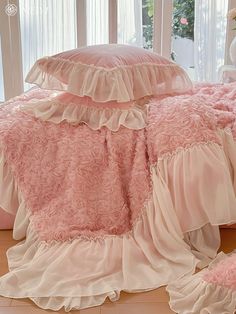 the comforter is pink and has ruffles on it, along with matching pillows