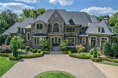 an aerial view of a large home surrounded by greenery