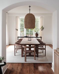 the dining room table is surrounded by chairs and an oval chandelier above it