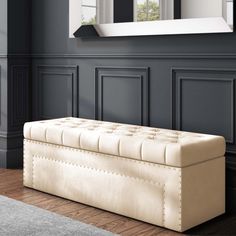 a white bench sitting in the middle of a living room next to a mirror and window