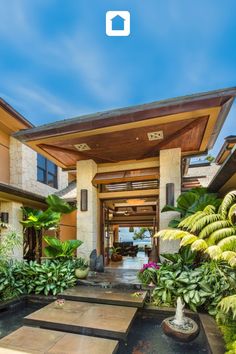 the front entrance to a house with plants and trees