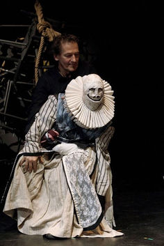 a man sitting on top of a wooden chair next to a woman in a white dress