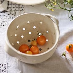 some tomatoes are in a bowl on a table