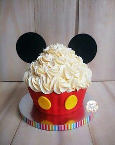 a mickey mouse cupcake with white frosting and ears