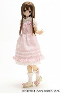 a doll with long hair wearing a pink dress and white socks, standing in front of a white background