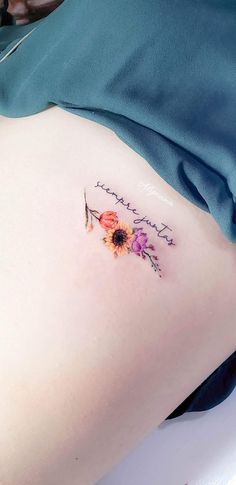 a small tattoo on the side of a woman's stomach