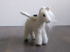 a white stuffed animal standing on top of a wooden floor