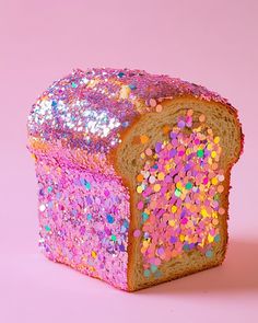 a piece of bread with sprinkles on it sitting in front of a pink background