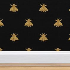 a black wall with gold bees on it