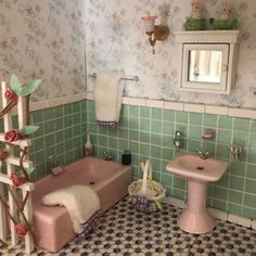 a doll house bathroom with pink bathtub, sink and toilet in the middle of it