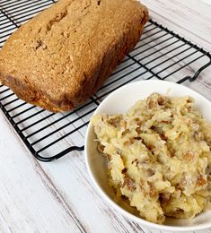 a bowl of mashed potatoes next to a loaf of bread on a cooling rack