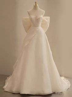 a white wedding dress on display in front of a mannequin's head