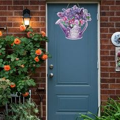 a blue front door with flowers on the side and a light hanging from it's side