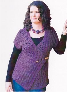 a woman is wearing a purple sweater and holding a cell phone in her right hand