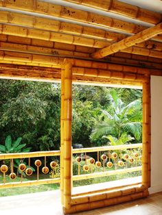 an empty room with wooden walls and flooring in front of a window that looks out onto the jungle