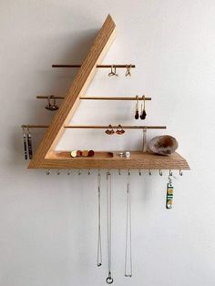 a wooden shelf with several pairs of earrings hanging from it's sides and two hooks on each side