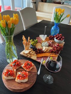 Charcuterie board with various cheeses meats and fruit pictured with tulips and a bruschetta board Couples Charcuterie Board, Red Wine Charcuterie Board, Chacuterie Board, Charcuterie Picnic, Wine Presentation, Date Night Ideas For Married Couples, 20 Birthday, Food Boards, 20th Birthday Party