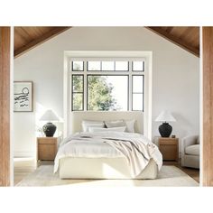 a white bed sitting under a large window in a bedroom next to two nightstands