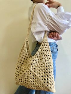 a woman holding onto a crocheted purse