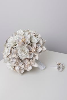 a bridal bouquet and earring set on a white table with grey background,