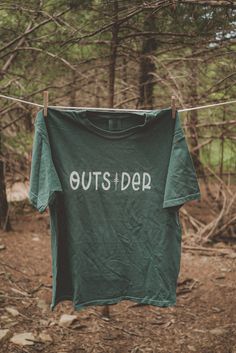 Outsider graphic t-shirt. Each t-shirt is pressed house on a comfort colors unisex shirt. T-shirts are made of a soft cotton blend and features a vibrant direct to fabric transfer design that won't fade or crack. COLOR PICTURED: LIGHT GREEN Shop our wanderlust inspired t-shirt collection. Perfect for those who enjoy hiking, camping, exploring the outdoors and all adventure seeking enthusiasts. keywords: outsider hiking shirt, wanderlust t-shirt, adventure t-shirts, graphic tees, unisex outdoorsy T Shirt Colors Ideas, Outdoor Graphic Tees, Outdoor T Shirt Design, Camp Merch, Adventure Graphic Design, Travel T Shirts, T Shirt Graphics, Hiking Design, Outdoorsy Shirt