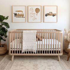 a baby's crib with three pictures on the wall