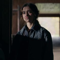 a woman standing in an empty building with her eyes closed and looking at the camera