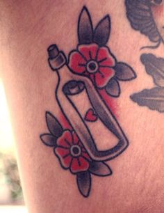 a woman's thigh with flowers and a bottle on the side that says love