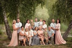 a large family posing for a photo in front of some trees