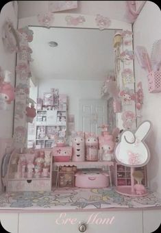 a pink vanity with hello kitty decorations on the top shelf and mirror in the middle